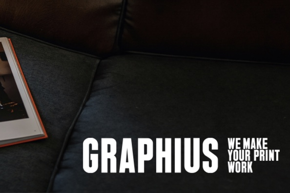 Het logo van Graphius naast een opengeslagen fotoboek op een donkere zetel.